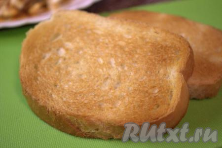 Нарезать на ломтики батон (или белый хлеб), выложить на сухую сковороду и подсушить на среднем огне до золотистого цвета с двух сторон (я подсушила ломтики хлеба в тостере).