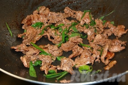 Перемешать и жарить кусочки говядины с зеленым луком не более 1 минуты.

