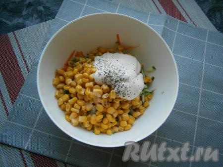 Посолить и поперчить салат из консервированной кукурузы,  свежих огурца и моркови, добавить несколько столовых ложек майонеза.