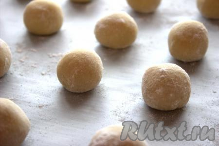 Выложить получившиеся шарики на противень, застеленный пергаментом, на расстоянии, примерно, 6-7 сантиметров друг от друга. Выпекать лимонное песочное печенье 13-15 минут (не пересушите) в духовке, разогретой до 180 градусов.