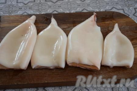 Кальмаров размораживаем, удаляем внутренности и хорду, а затем отвариваем в кипящей воде в течение 2 минут. Отваренных кальмаров промываем под холодной водой, а затем очищаем от плёнки. 