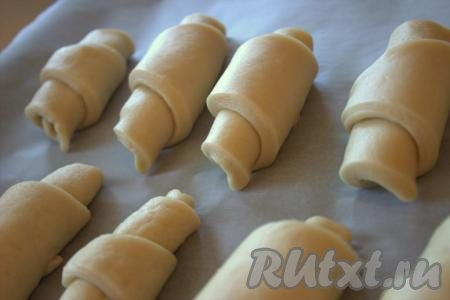 Рогалики, сформированные из постного дрожжевого теста, выложить на противень, застеленный бумагой для выпечки. На расстойку эту выпечку оставлять не нужно.