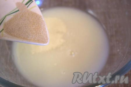 В глубокую миску влить тёплую воду, температура которой не должна быть выше 40 градусов. Затем в воду добавить небольшими порциями сухие дрожжи, тщательно перемешивая. Затем влить растительное масло. 