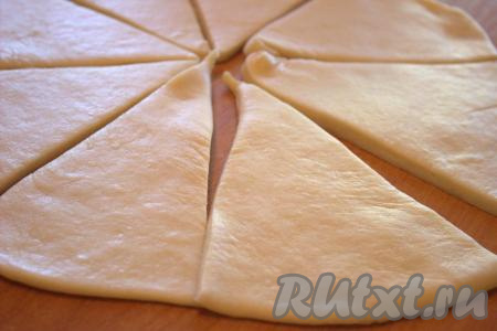 Затем слегка обмять тесто и&nbsp;разделить на 3-4 равные части. Каждую часть теста на столе, припылённом мукой, раскатать в круг диаметром 25-26 сантиметров, толщиной 0,5-1 сантиметр. Разделить каждую часть раскатанного теста на 8-10&nbsp;секторов.