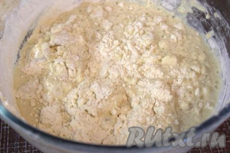 Затем в миску всыпать частями просеянную муку, тщательно перемешивая ложкой, а затем хорошо вымесить тесто руками.