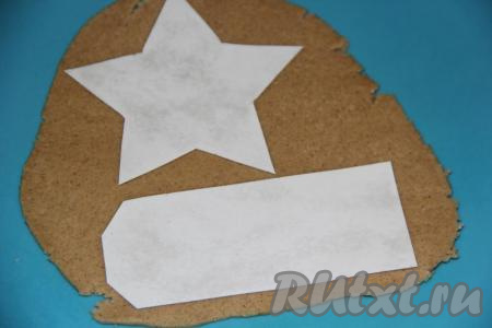 Выложить подобающие 23-му февраля трафареты (у меня погоны, звёзды и парашюты) на тесто и вырезать печенье с помощью ножа.