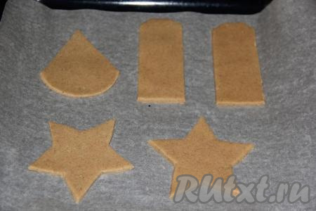 Противень застелить пергаментом и выложить вырезанное печенье.