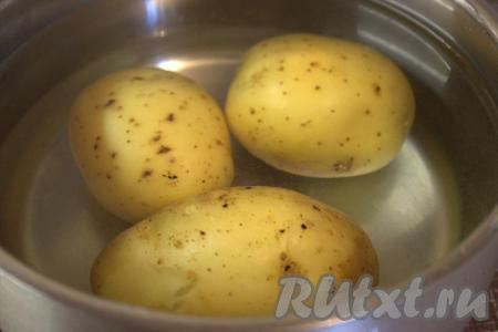 Тщательно вымыть картофелины и, не очищая от кожуры, выложить в кастрюлю, полностью залить водой, отправить на огонь. После закипания воды варить на медленном огне 20-25 минут (до готовности - сваренные клубни должны легко прокалываться вилкой или ножом). Слить воду из кастрюли с картошкой и дать картофелинам слегка остыть.