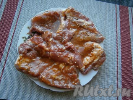 Ломти мяса немного отбить молоточком, посолить и щедро смазать медово-горчичным соусом со всех сторон. Оставить свинину для маринования на 1 час при комнатной температуре.