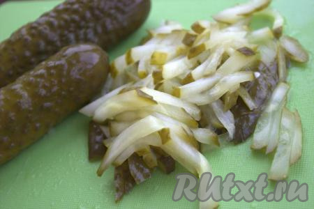 Солёные огурцы нарезать тонкой соломкой.