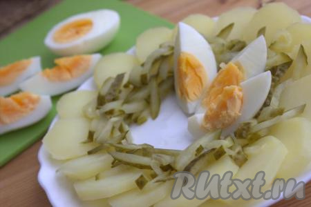 Затем в центр салата выложить дольки яиц.