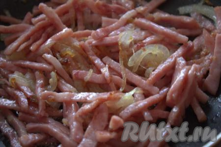 Затем в сковороду к луку добавить нарезанную ветчину и обжаривать на среднем огне минут 5, иногда перемешивая, затем, сняв с огня, дать остыть в течение нескольких минут.