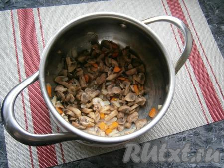 Перемешать шампиньоны с морковкой и луком и обжаривать в кастрюле, помешивая, на небольшом огне до тех пор, пока грибы не начнут поджариваться (3-5 минут).