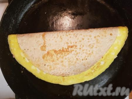 Обжарить лаваш с начинкой из яичницы, колбасы и сыра до золотистого цвета с двух сторон на среднем огне.