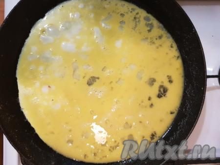 Разогреть сковороду со сливочным маслом и влить яйца, равномерно распределив по сковороде.