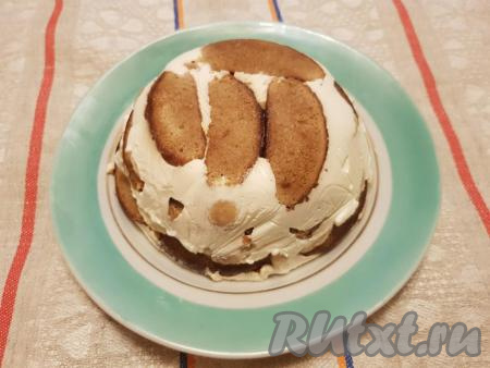 Перевернуть торт из пряников и бананов со сметаной на плоское блюдо, убрать пищевую плёнку.