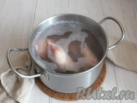 Разморозьте кальмаров при комнатной температуре (или на нижней полке холодильника). Тщательно вымойте тушки кальмаров, снимите кожицу, удалите внутренности и хорду. В небольшой кастрюле вскипятите воду с добавлением 1 столовой ложки соли и лаврового листа. В кипящую воду опустите подготовленных кальмаров, как только вода повторно начнёт закипать, засеките 2 минуты и проварите тушки в течение этого времени, затем снимите с огня кастрюлю.