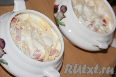 Залить получившейся смесью пельмени. Сыр натереть на тёрке и выложить поверх пельменей и ветчины.