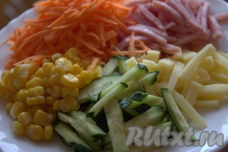 Соединить в миске сыр, морковку, колбасу и огурец, добавить консервированную кукурузу без жидкости.