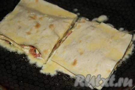 В сковороду влить немного растительного масла, разогреть. Квадратики из лаваша с начинкой полностью обмакнуть в кляр и выложить в сковороду.