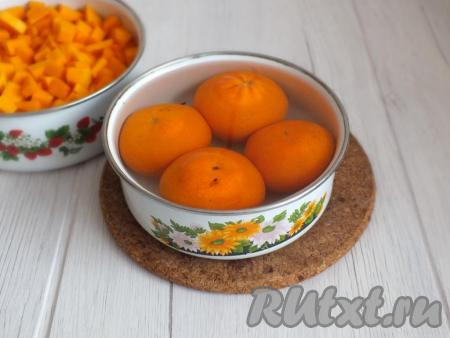 Далее подготовьте мандарины. Вымойте, затем поместите в чашу и залейте крутым кипятком на 15 минут.