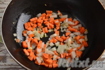 На сковороду влейте и раскалите 1 столовую ложку растительного масла, выложите нарезанные лук с морковкой и обжаривайте на слабом огне в течение 5-6 минут, помешивая, затем переложите в кастрюлю. Получается, что между этапом загрузки картофеля и загрузкой в кастрюлю обжаренных овощей проходит 7-8 минут.
