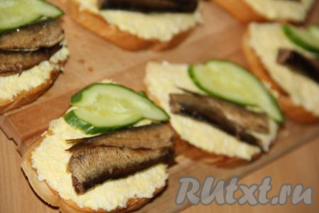 Свежий огурец вымыть и нарезать на кружочки. Выложить по одному кружочку огурца на бутерброд.