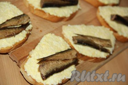 На каждый бутерброд, смазанный смесью яиц и майонеза, выложить по 2 шпротинки.