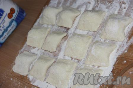 Выложить вареники на поверхность, припылённую мукой. Таким образом сформировать все вареники с замороженной малиной. У меня получилось 20 вареников. Часть вареников с ягодами я выложила на доску, отправила в морозилку и заморозила впрок.