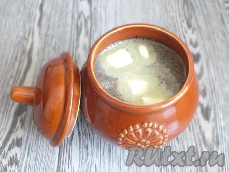 Выложите крупы&nbsp;с луком, залейте 300 мл тёплой&nbsp;воды, сверху положите оставшиеся 30 грамм сливочного масла. Накройте горшочек крышкой и поставьте в разогретую до 180 градусов духовку на 30 минут.