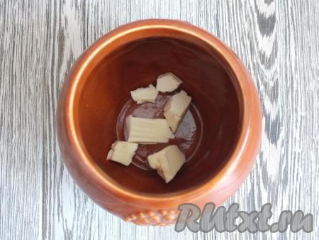 Возьмите керамический горшочек пригодный для запекания в духовке (я взяла горшочек объёмом 600 мл). На дно горшочка положите 30 грамм сливочного масла.