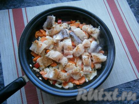 Обжарить лук, перец и морковку в течение 3-4&nbsp;минут на небольшом огне, периодически перемешивая. Затем выложить кусочки хека.