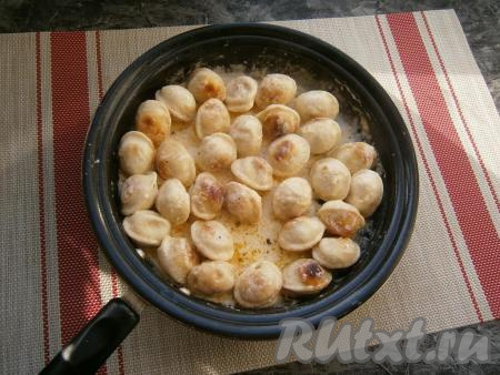 Прикрыть сковороду крышкой и протушить пельмени со сметаной на слабом огне минут 8-10.