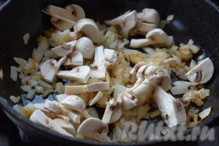 В сковороде разогреем растительное масло и отправим жариться лук до прозрачности на среднем огне, иногда перемешивая. Далее выкладываем к луку нарезанные шампиньоны.
