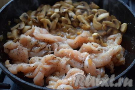 Когда грибы и лук поджарились, сдвигаем их в сторону, а на освободившееся на сковороде место выкладываем кусочки куриного филе.