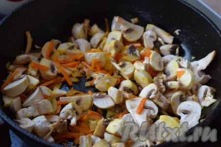 Отправляем шампиньоны (или отваренные лесные грибы) в сковороду к луку и моркови, слегка подсаливаем и томим овощи с грибами на медленном огне до готовности грибочков (примерно, 7-8 минут), иногда перемешивая.