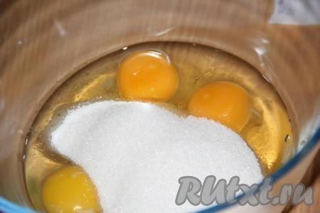 Вбить 3 яйца в глубокую миску, всыпать сахар.