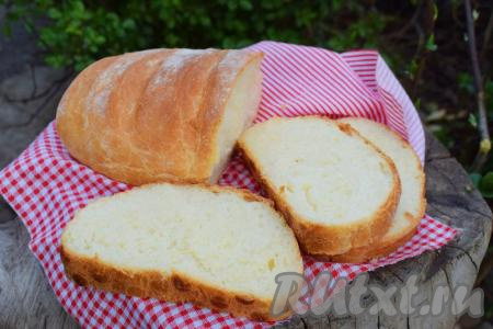 Достаём наш румяный батон из духовки и даём ему отлежаться до остывания, накрыв свежую выпечку полотенцем. Батон, приготовленный в домашних условиях, получается невероятно нежным, мягким, вкусным, при разрезании не крошится, у него однородная и мелкопористая текстура мякиша.