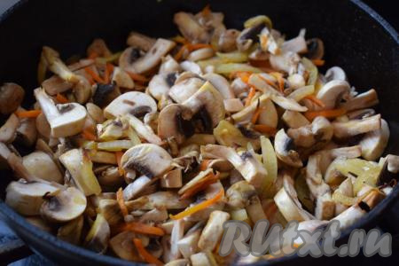 К обжаренным луку и моркови добавляем шампиньоны и обжариваем на маленьком огне до готовности грибов (примерно, 7-8 минут).
