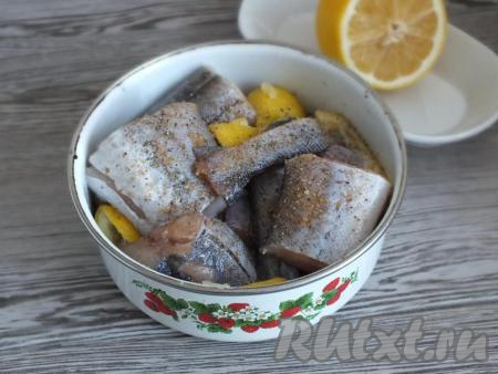 Нарежьте подготовленную рыбу на кусочки желаемого размера, переложите в миску, посолите, поперчите и добавьте дольки лимона, перемешайте и оставьте при комнатной температуре минут на 20 (пока готовятся овощи в мультиварке).