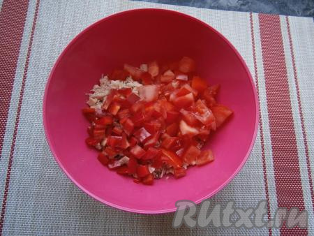 Сладкий перец, предварительно очищенный от семян, и свежий помидор нарезать кубиками и выложить к куриному мясу.