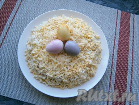 Салат сверху и с боков обсыпать натёртыми куриными яйцами, по середине выложить горку натёртого сыра. Перепелиные яйца очистить и окрасить в разные цвета: соком свеклы, а также куркумой, разведённой в воде, и соком краснокочанной капусты (для окрашивания перепелиные яйца нужно просто покатать в соках или в растворе куркумы - они быстро окрасятся), дать обсохнуть. Разместить окрашенные перепелиные яйца в центре салата.