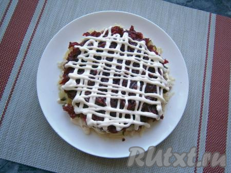 Далее идёт слой натёртой на средней тёрке свеклы (ломтик оставить для украшения), посолить, покрыть сеточкой из майонеза.