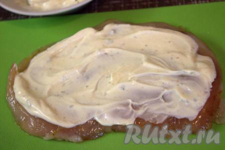 Каждый промариновавшийся кусочек филе смазать смесью майонеза, сметаны и чеснока.