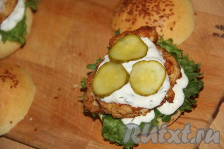 Смазать курицу соусом и выложить кружочки маринованного огурца.