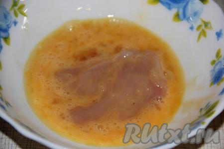 Обмакнуть каждый пласт куриного филе в яйцо.
