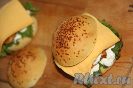 Поверх огурцов выложить ломтик сыра и накрыть второй частью булочки.