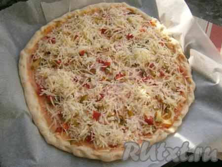 Сыр натереть на средней тёрке и щедро  посыпать пиццу сверху.