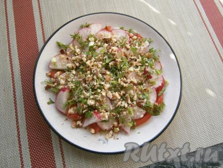 Посыпать помидоры с редиской измельчённой зеленью укропа и лука, полить заправкой из подсолнечного масла, сока лимона и сахара, а сверху посыпать салат орехами.