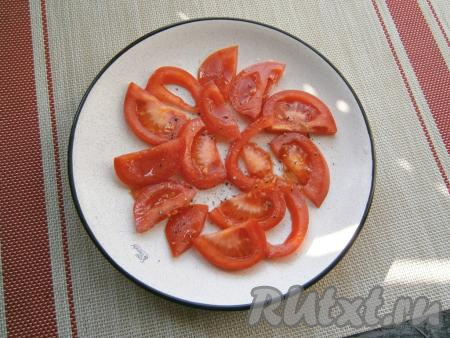 Помидоры нарезать дольками и выложить их на плоскую тарелку в один слой, чуть посолить и поперчить.